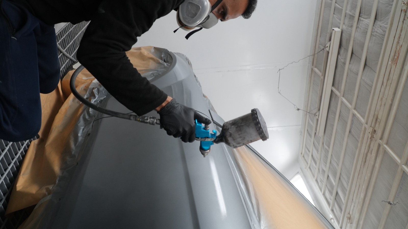 Technician spraying a panel in the paint booth